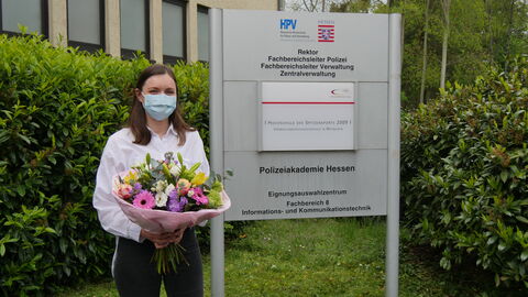 Laura Seiwerth Laura Seiwerth vor dem Hinweisschild zur HöMS mit Blumenstraus