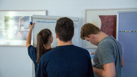 Junge Menschen beim Lernen. Junge Studierende, die auf einem Flipchart Notizen machen und Lernen