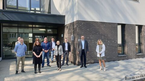Mehrere Personen vor dem Neubau des Studierendengebäudes des Campus Kassel