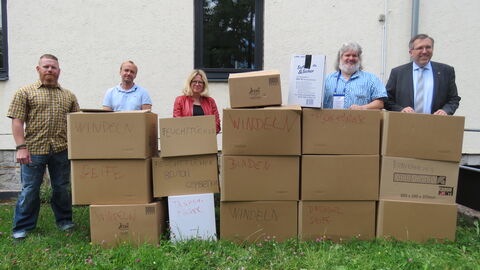 Menschen mit Hilfsgütern in Kartons für die Ukraine