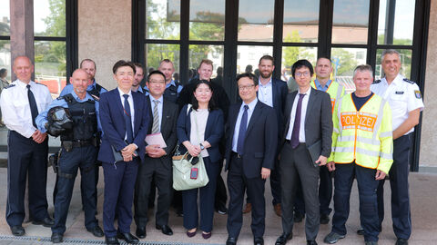 Besuch der Delegation aus Japan Gruppenbild Delegierte mit Beschäftigten der HöMS vor dem Einsatztrainingszentrum