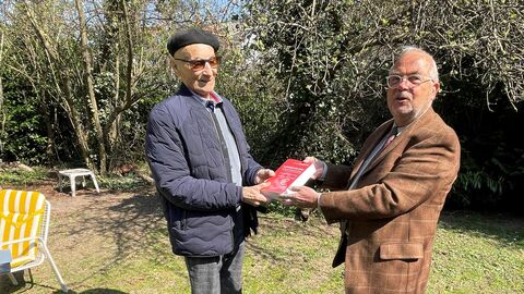 Harald Dörrschmidt (links) und Klaus Slapnicar (rechts) halten gemeinsam ein Buch in einem Garten