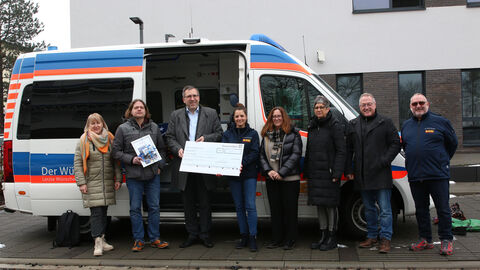 Foto zeigt die Spendenübergabe am Campus Kassel an den ASB Wünschewagen aus Nordhessen
