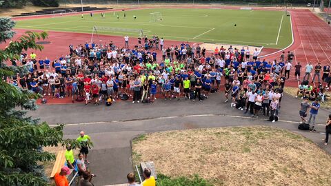 Sporttag am Campus Kassel - Gruppenbild mit Teilnehmerinnen und Teilnehmern Sporttag am Standort in Kassel - Gruppenbild von Teilnehmenden, im Hintergrund Fußballplatz und Laufbahn