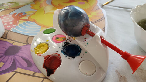 zu sehen ist ein hart gekochtes Ei auf einem Gestell zum bemalen mit Farben