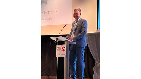 Begrüßung durch Campusdekan Prof. Dr. Elmar Schmitz (Wiesbaden) Campusdekan für Wiesbaden, Porf. Dr. Elmar Schmitz, steht vor hinter einem Rednerpult