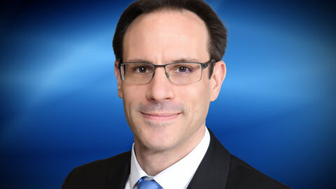 Vizepräsident Prof. Dr. Thorsten Göbel steht vor einer Wand, er trägt Hemd, Krawatte und Hemd und blick in die Kamera