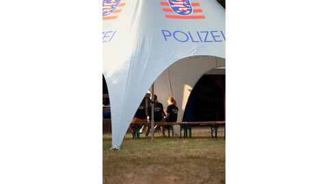 Das Bild zeigt drei Teilnehmer des Blaulichtcamps von hinten, die entspannt in eine großen Zelt auf Bierzeltgarnituren sitzen. Sie wirken in ein Gespräch vertieft. Das Bild zeigt drei Teilnehmer des Blaulichtcamps von hinten, die entspannt in eine großen Zelt auf Bierzeltgarnituren sitzen. Sie wirken in ein Gespräch vertieft.