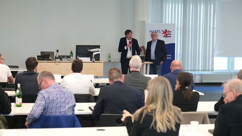 Begrüßung durch die Forschungsdirektoren Dipl.-Pol. Dipl.-Psych. Hermann Groß und Prof. Dr. Julian Junk Forschungsdirektoren Dipl.-Pol. Dipl.-Psych. Hermann Groß und Prof. Dr. Julian Junk stehen vor Publikum