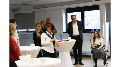 Vorstellung des Zentrums für Fort- und Weiterbildung durch die Leiterin Anna Elzer Anna Elzer (ZFW) steht an einem Tisch und stellt ihr Zentrum vor.