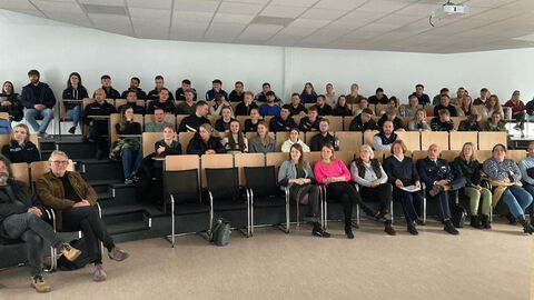 Teilnehmende der Veranstaltung im Audimax Campus Kassel Blick auf Teilnehmende der Eröffnungsveranstaltung auf einer Tribüne
