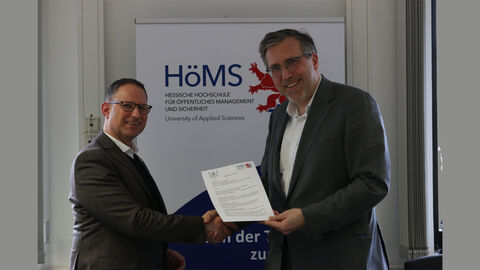 Steve Landau und Dr. Walter Seubert zeigen Kooperationsvereinbarung in die Kamera