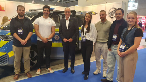 Gruppenbild in Messehalle mit Peter Beuth vor hessischem Polizeiauto Gruppenbild in Messehalle mit Peter Beuth vor hessischem Polizeiauto