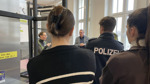 Exkursionsteilnehmende hören der Historikerin Juliane Hanzig der Polizei Sachsen zu.